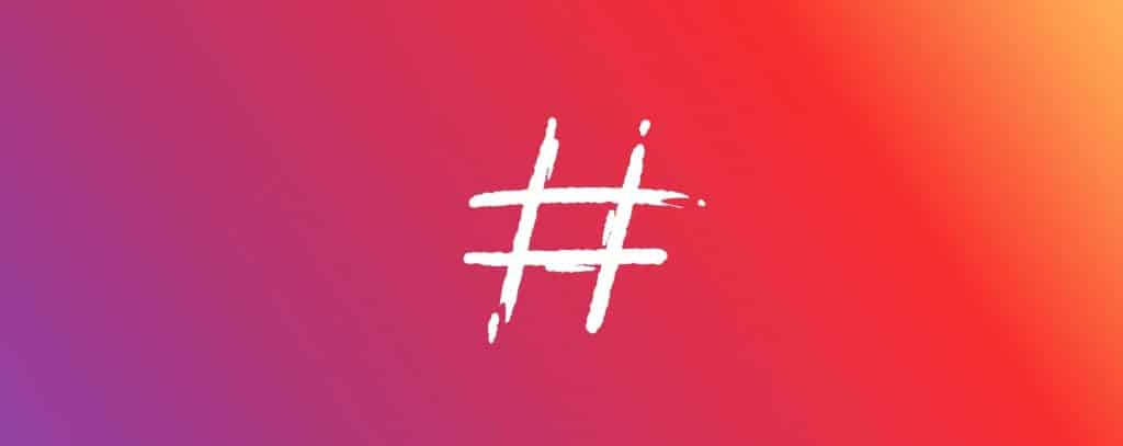 White hashtag over purple and red gradient background. Background colors all blending in with each other.