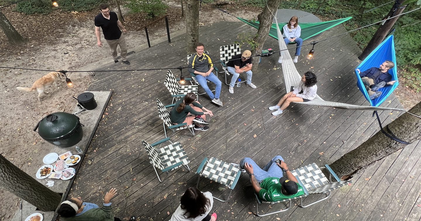 First Ascent team sitting in a circle on a cabin patio.